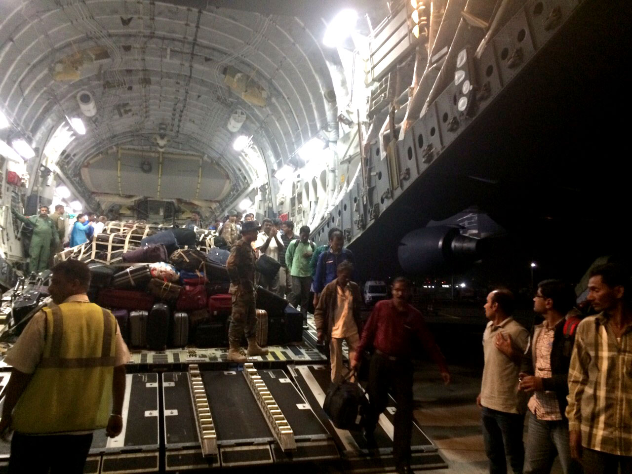 Evacuated men and women from war-torn Yemen walk out of tail-hatch of Indian Air Force transport aircraft on April 02, 2015.