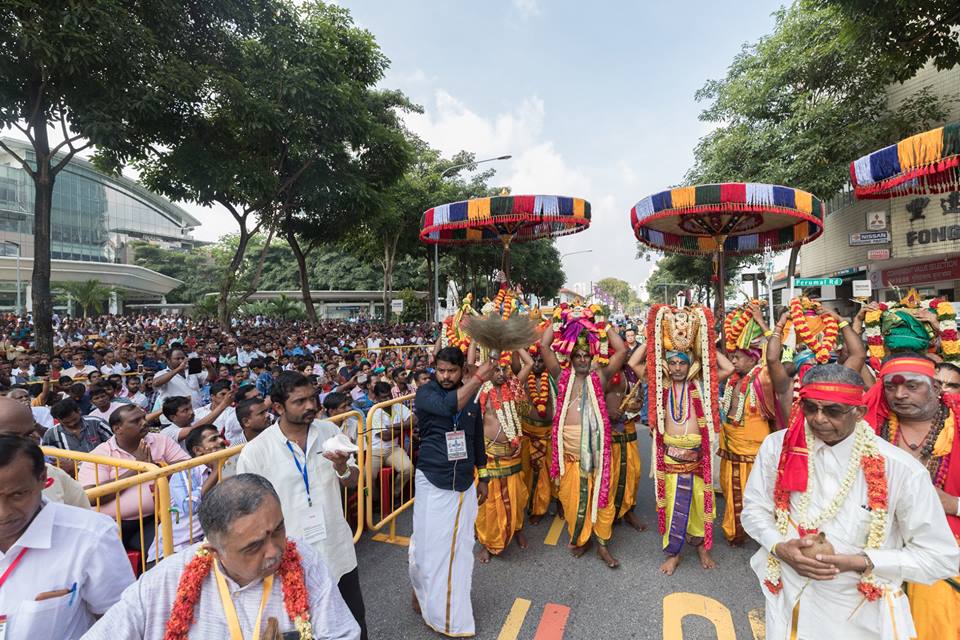 Devotees braving the hot sun to witness the consecration ceremony of Sri Srinivasa Perumal Temple. The priests are carrying the vessels with holy water from Perumal Road to the temple towers. 